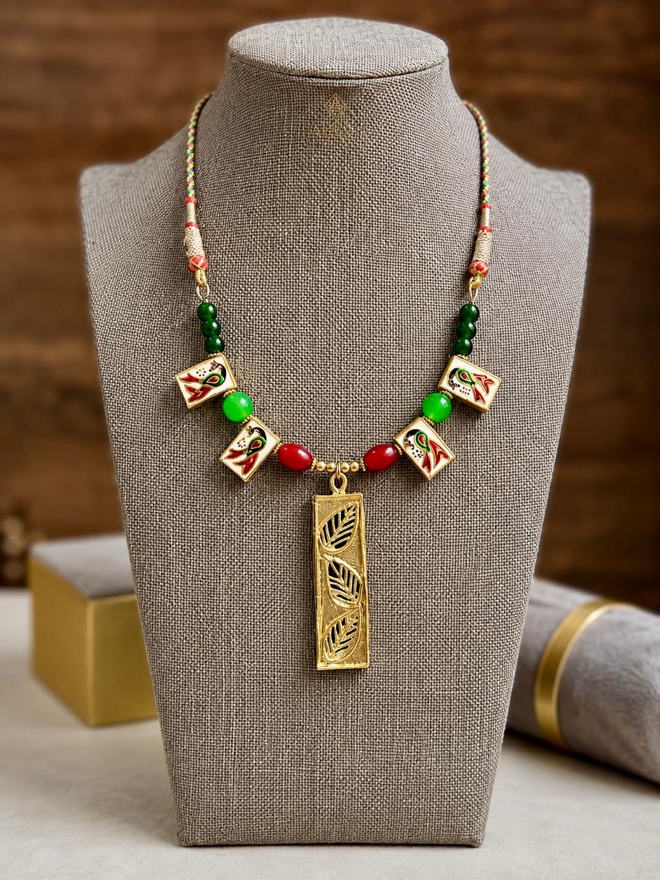 Meenakari enamel peacock charms in red, green and gold on a multicoloured braided cord with glass beads