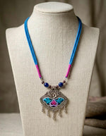 Cobalt lapis beads on a blue and pink cord with slim oxidised silver drops below the pendant